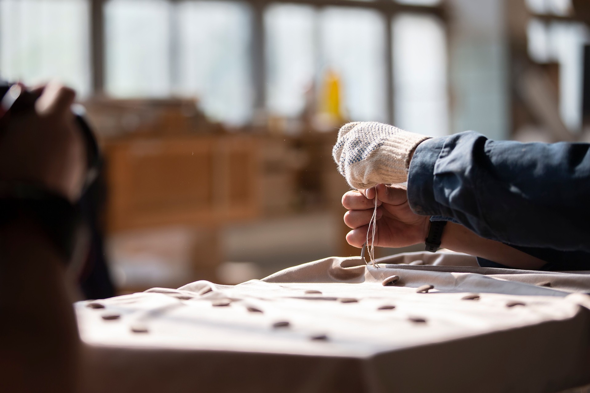 Arbeiterhände machen Möbel. Machen Sie einen Wagen Estrich auf dem Sofa.